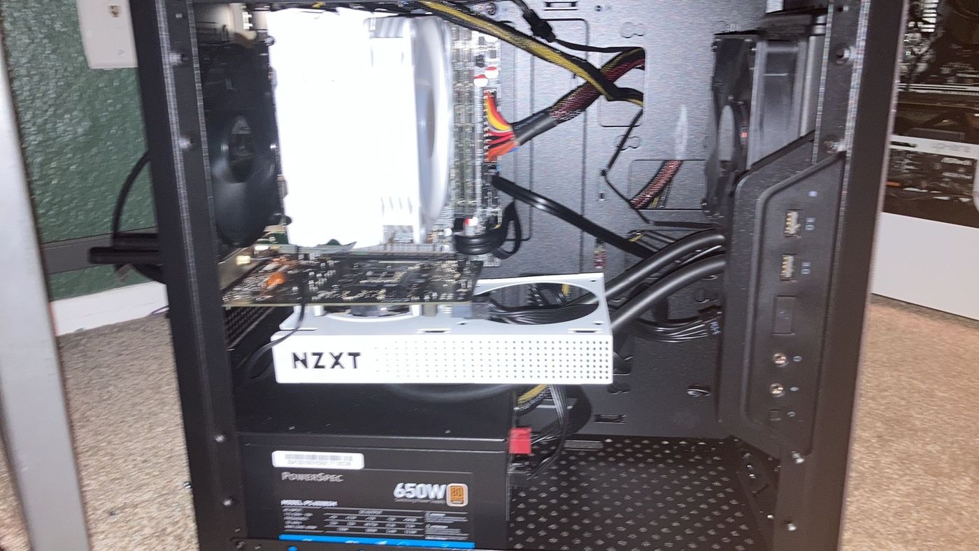 Full build inside the case — NZXT Kraken G12 radiator mounted in the GPU slot, PowerSpec 650W PSU, questionable cable management