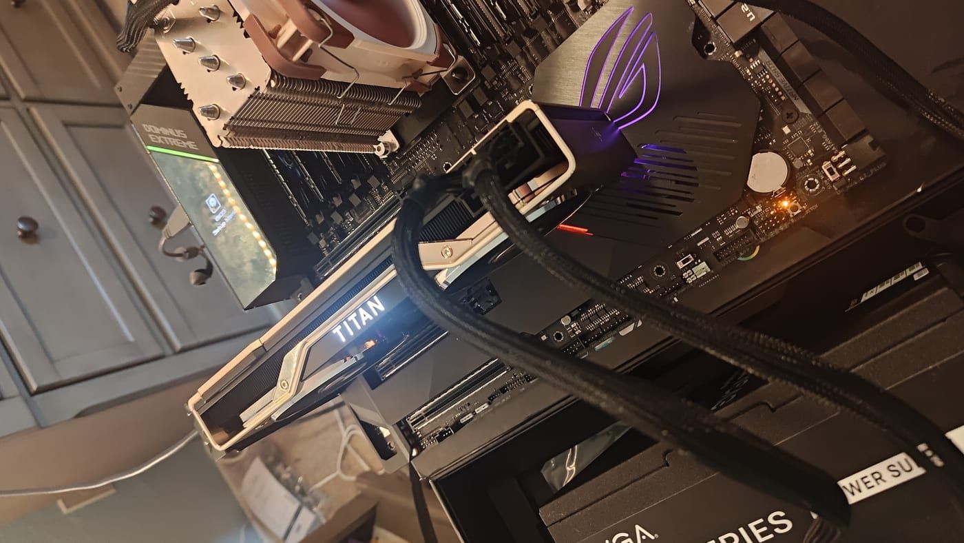 Wide angle — Titan RTX glowing TITAN in white, ROG logo in blue, Noctua cooler, full open-air bench setup