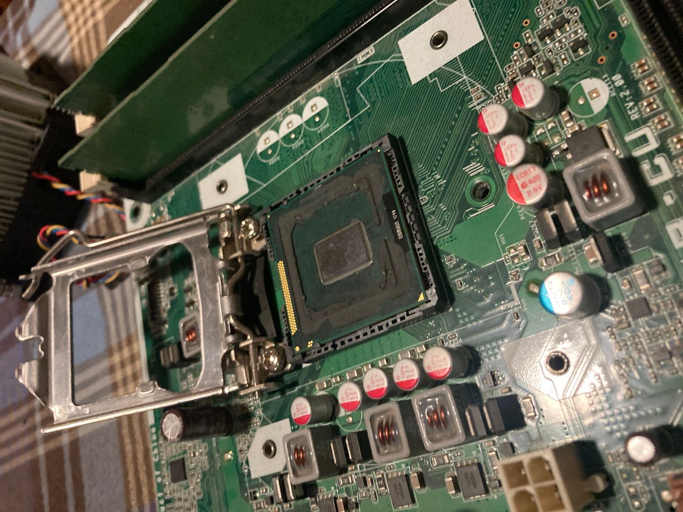Delidded Pentium seated in socket — bare die exposed, IHS removed, socket retention bracket open