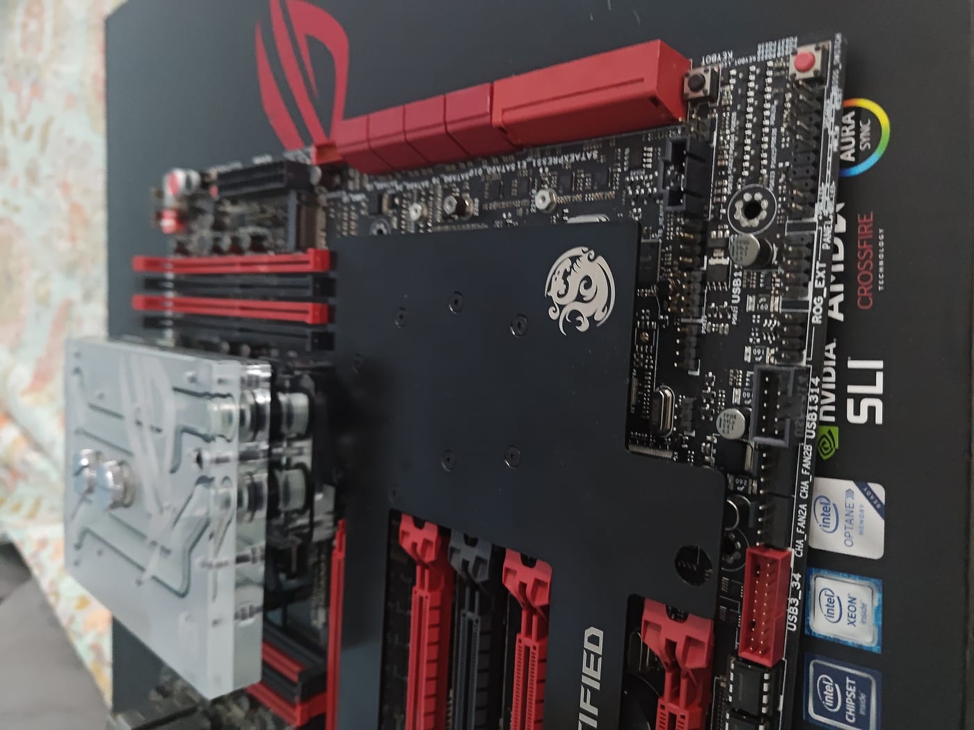 Bottom right of the Rampage V Extreme PCB — ROG Certified badge silkscreened on board, PCIe slot stack, Aura Sync and SLI badges