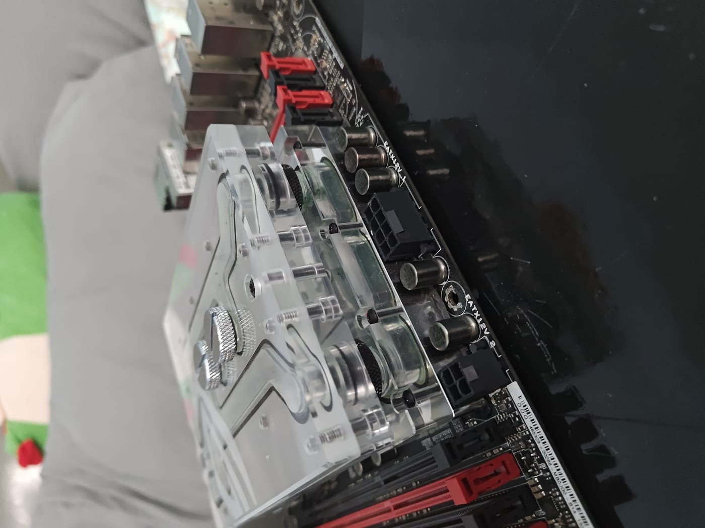 Back of monoblock — clear acrylic sections, VRM extension connecting to the main block, chrome hardware detail